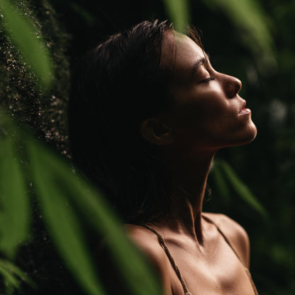 model in seychelles jungle smelling coco de mer